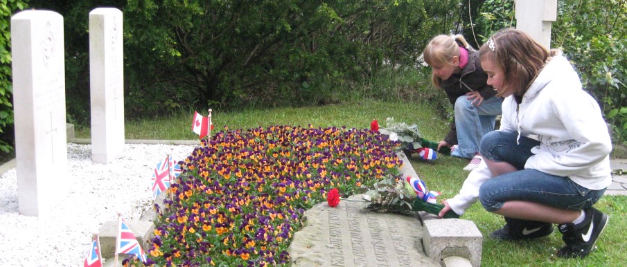 bloemen neerleggen bij oorlogsgraven